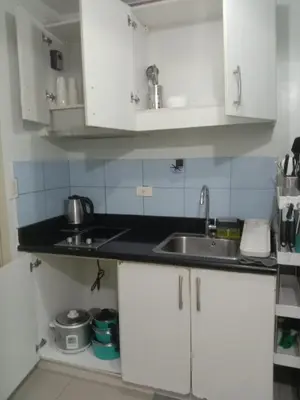 a kitchen with white cabinets and a sink at Luxurious Condo in the Heart of Makati Philippines in Manila