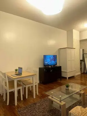 a living room with a table and a tv at Spacious Studio in Mosaic Tower no Balcony in Manila