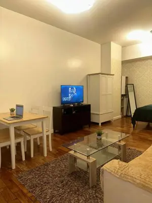 a living room with a television and a table at Spacious Studio in Mosaic Tower no Balcony in Manila