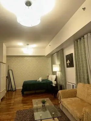 a living room with a bed and a couch at Spacious Studio in Mosaic Tower no Balcony in Manila