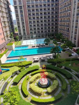 a garden in front of a large building with a pool at Near Moa Facing pool view WP1603 Monarch Parksuites in Manila