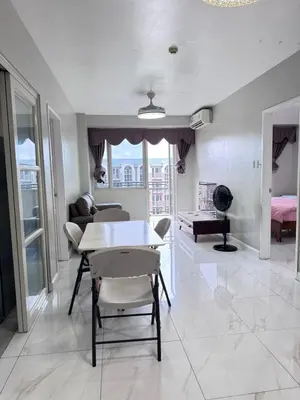 a living room with a table and a couch at Near Moa Facing pool view WP1603 Monarch Parksuites in Manila