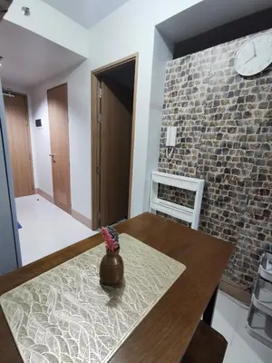 a dining room with a table and a brick wall at Mall of Asia condotel shore 3 residence in Manila