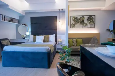 a bedroom with a bed and a living room at One Bedroom Unit with Venice Canal View in Manila