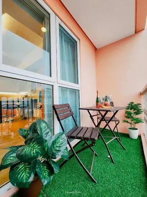 a chair and a table and a plant in a room at One Bedroom Unit with Venice Canal View in Manila