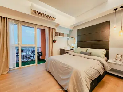 a bedroom with a large bed and a balcony at One Bedroom Unit with Venice Canal View in Manila