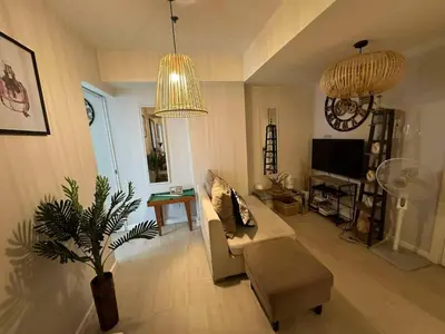 a living room with a couch and a potted plant at Azure Staycations by MM 1 in Manila