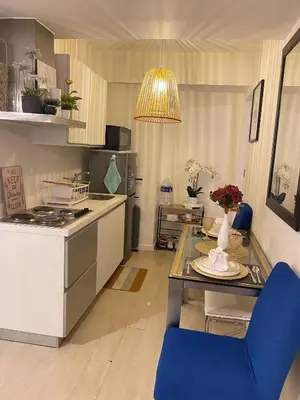 a kitchen with a stove and a table with a blue chair at Azure Staycations by MM 1 in Manila