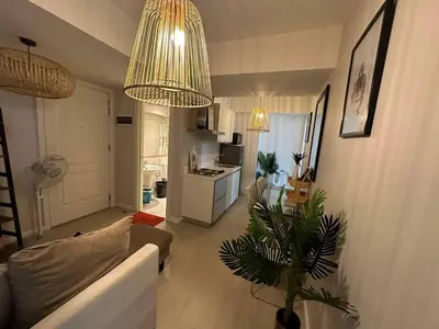 a living room with a couch and a table with a plant at Azure Staycations by MM 1 in Manila