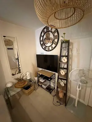 a living room with a large clock on the wall at Azure Staycations by MM 1 in Manila