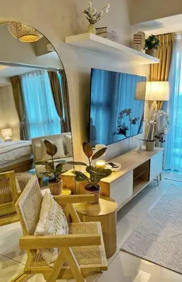 a living room with a large tv and a couch at Cozy & Stylist Unit in BGC in Manila
