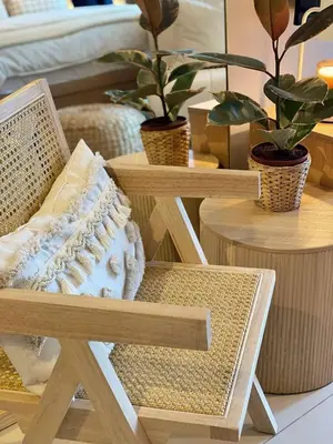 a wooden chair and a table with potted plants at Cozy & Stylist Unit in BGC in Manila