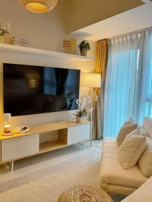a living room with a large flat screen tv at Cozy & Stylist Unit in BGC in Manila