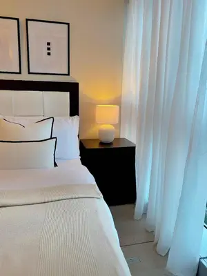 a bedroom with a bed with white curtains and a lamp at Cozy Netflix and Chill in BGC in Manila