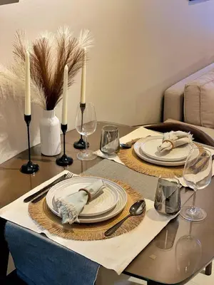 a table with two plates and wine glasses on it at Cozy Netflix and Chill in BGC in Manila