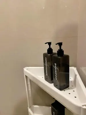 two bottles ofodorizers sitting on a shelf in a bathroom at Cozy Netflix and Chill in BGC in Manila