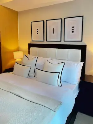 a large white bed with three pillows on it at Cozy Netflix and Chill in BGC in Manila