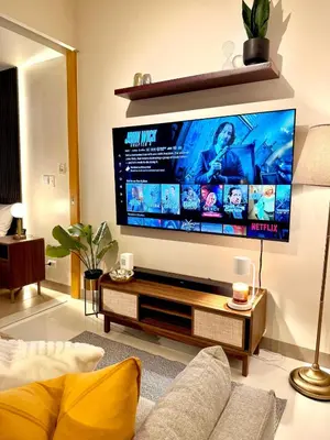 a living room with a large flat screen tv at Netflix and Chill Cozy Unit BGC in Manila