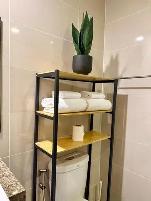 a bathroom with a toilet and a plant on a shelf at Netflix and Chill Cozy Unit BGC in Manila