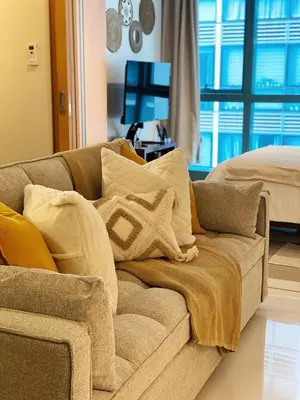 a couch with pillows on it in a living room at Netflix and Chill Cozy Unit BGC in Manila
