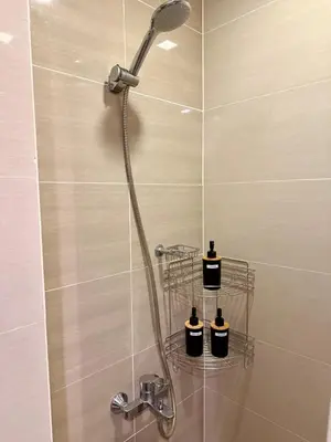 a shower with a shower head in a bathroom at Netflix and Chill Cozy Unit BGC in Manila