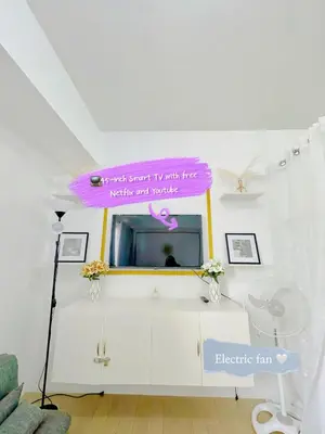 a living room with a tv and a pink sign at Chill Luxe Vista in Manila