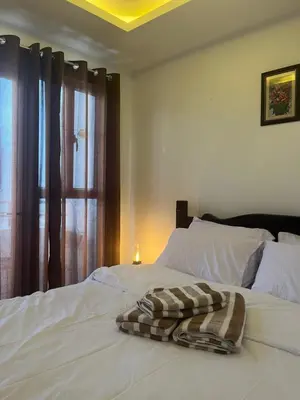 a white bed with a blanket on it with a window at JFS Home at Birch Tower in Manila