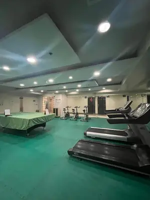 a gym with several treadmills and exercise bikes in it at JFS Home at Birch Tower in Manila
