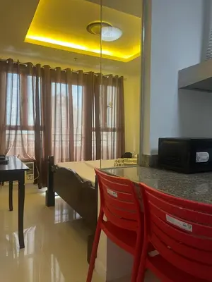 a kitchen with a table and two red chairs at JFS Home at Birch Tower in Manila