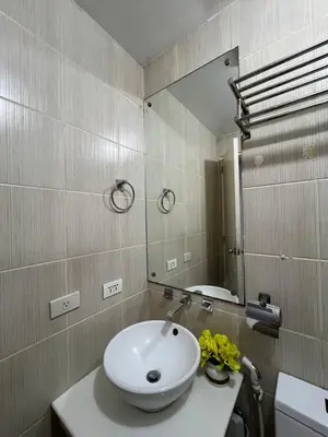 a bathroom with a white sink and a mirror at JFS Home at Birch Tower in Manila