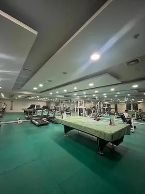 a gym with several machines and a green floor at JFS Home at Birch Tower in Manila