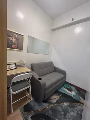 a living room with a couch and a desk at Regalia's Pod in Trece Martires