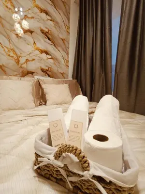 a basket of towels on top of a bed at Regalia's Pod in Trece Martires