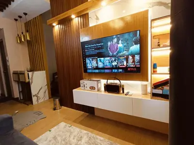 a living room with a large television on a cabinet at Regalia's Pod in Trece Martires