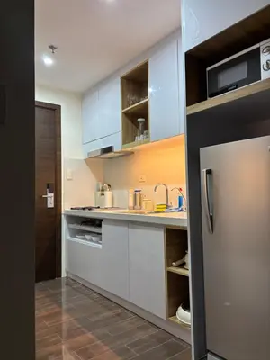 a kitchen with white cabinets and a stainless steel refrigerator at Yanah Stays in Manila