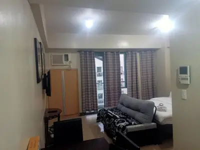 a living room with a couch and a bed at Affordable Condoatel Hotel Near Naia 1,2,34 in Manila