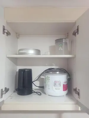 a kitchen shelf with a toaster and a slow cooker at Affordable Condoatel Hotel Near Naia 1,2,34 in Manila