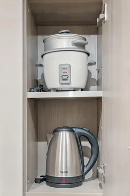 a pot and a tea kettle in a cabinet at The Sunny Flat at Fame Residences near SM Megamall, Shangrila in Manila