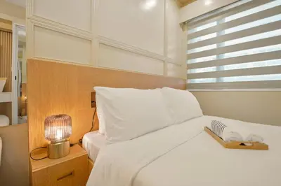 a bedroom with a white bed and a window at The Sunny Flat at Fame Residences near SM Megamall, Shangrila in Manila
