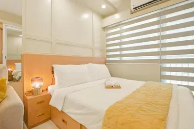 a bedroom with a large white bed and a window at The Sunny Flat at Fame Residences near SM Megamall, Shangrila in Manila