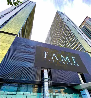 a tall building with a sign in front of it at Fame Residences One-Bedroom Condo Unit in Manila