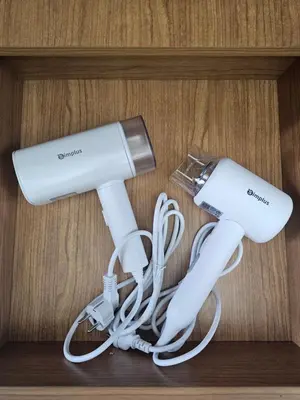 two white video game controllers on a shelf at MOA Shell Residences Spacious 1BR with City View WiFi and Netflix in Manila