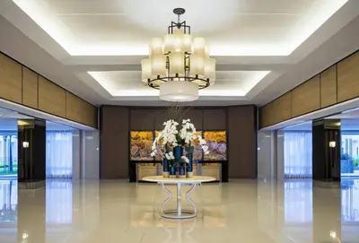 a lobby with a table with flowers and a chandelier at MOA Shell Residences Spacious 1BR with City View WiFi and Netflix in Manila
