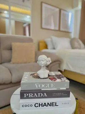 a stack of books sitting on a table in a living room at Aurbana Staycation in Manila