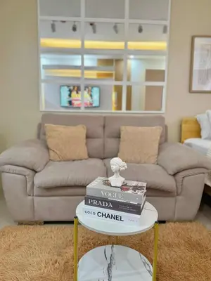 a living room with a couch and a table with books at Aurbana Staycation in Manila