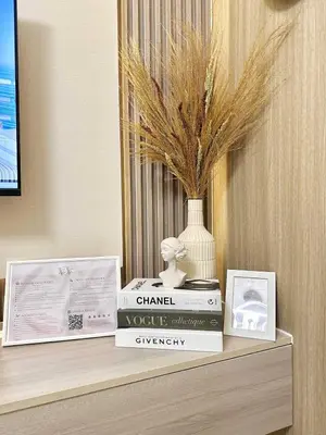 a shelf with two books and a vase on it at Aurbana Staycation in Manila