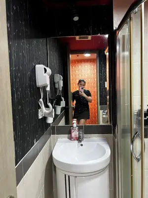 a person taking a picture in a bathroom mirror at Vintage Luxx-Solemare Parksuites Free Pool Access! in Manila