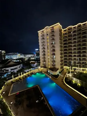 a view of a building with a pool at night at Vintage Luxx-Solemare Parksuites Free Pool Access! in Manila