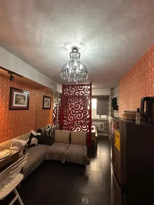 a living room with a couch and a chandelier at Vintage Luxx-Solemare Parksuites Free Pool Access! in Manila