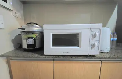 a microwave and a slow cooker on a kitchen counter at Explore Mitsukoshi Uptown BGC, large TV, fast WIFI in Manila